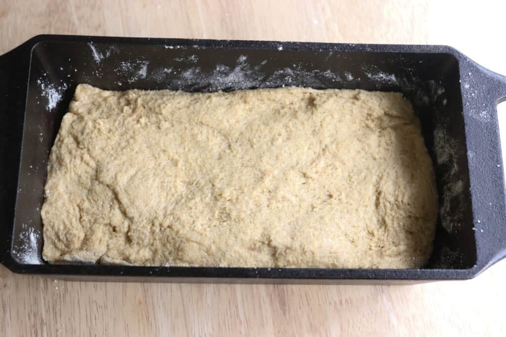 freshly milled english muffin toasting bread dough rising in a cast iron pan