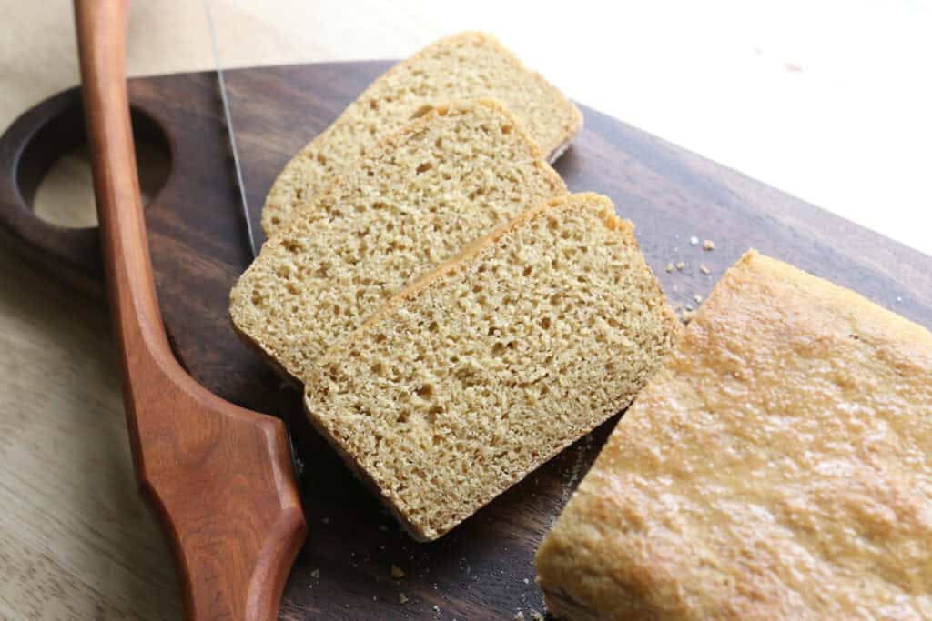 3 slices of freshly milled english muffin toasting bread with a bread knife