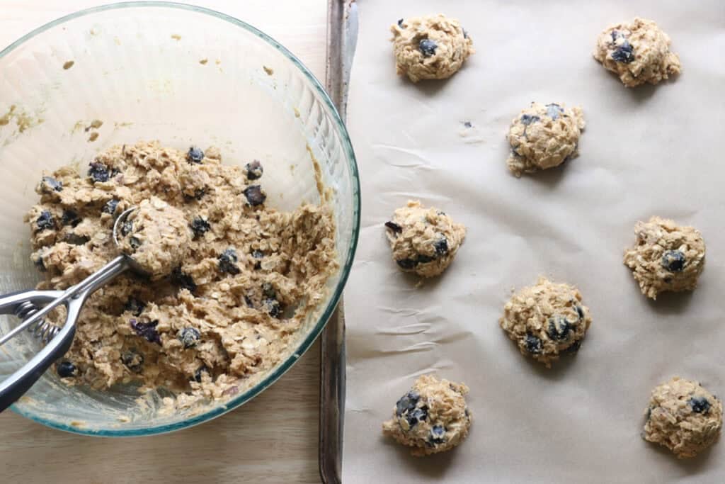 freshly milled blueberry cheesecake oatmeal cream pie batter scooped into cookies on a baking sheet