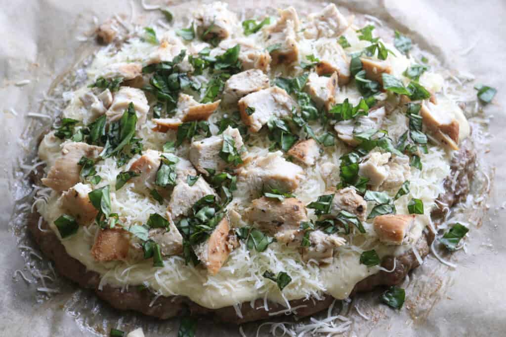 High protein chicken crust chicken alfredo pizza with fresh basil on top