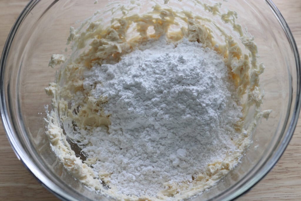 butter and powdered sugar in a bowl to make the icing for freshly milled blueberry cheesecake oatmeal cream pies