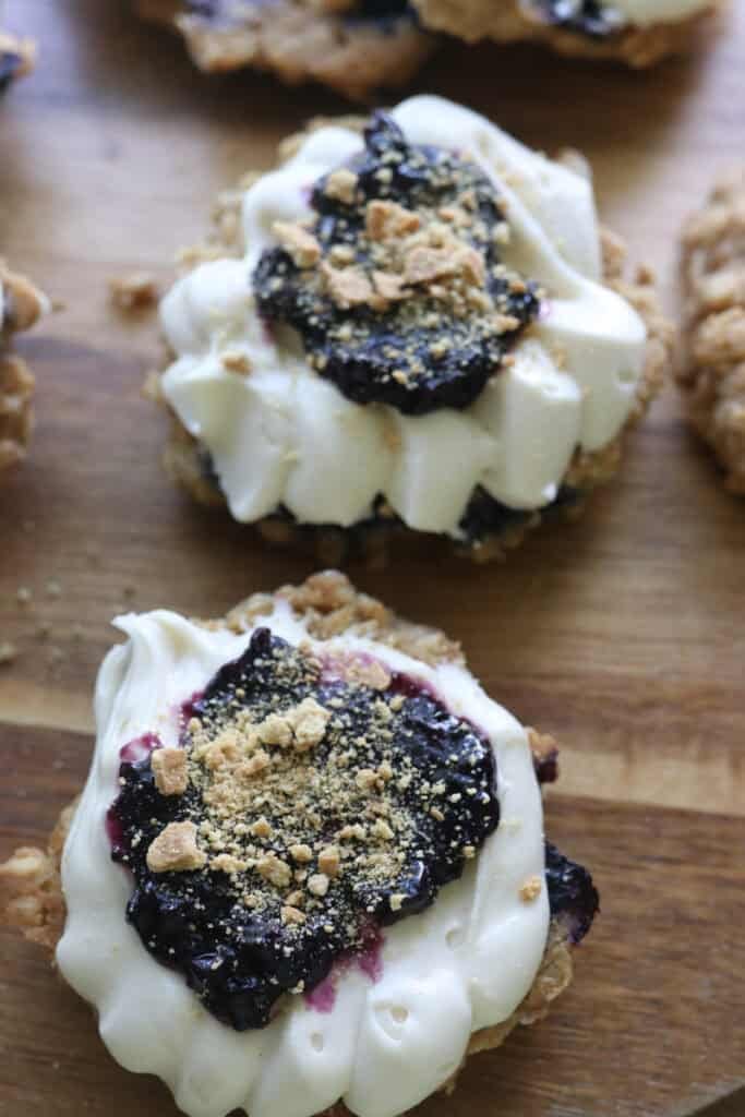 a freshly milled blueberry cheesecake oatmeal cream pie with icing and jam and graham crackers