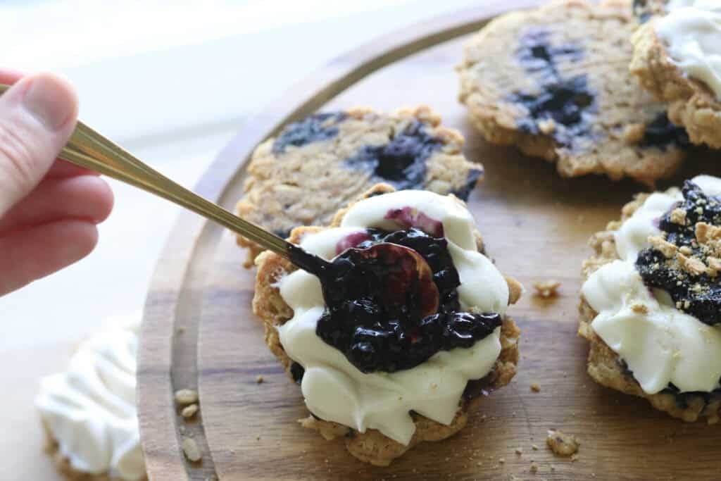 adding blueberry jam to the freshly milled blueberry cheesecake oatmeal cream pies
