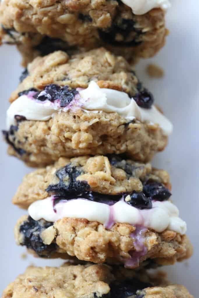 freshly milled blueberry cheesecake oatmeal cream pies stacked together in a white dish