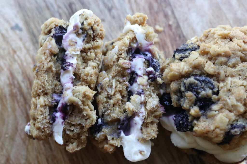 a freshly milled blueberry cheesecake oatmeal cream pie cut in half