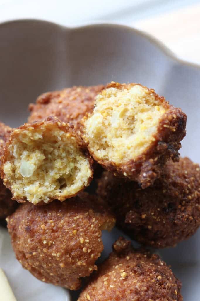 Freshly milled hush puppies that have been fried and in a bowl