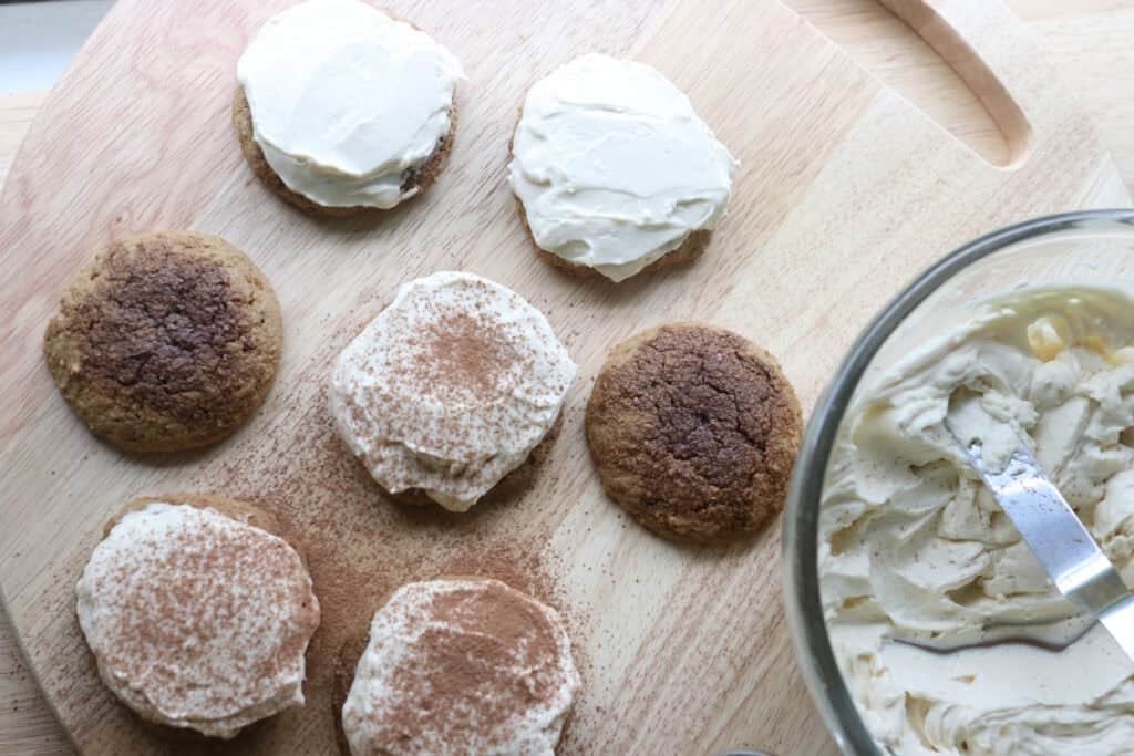 Freshly milled tiramisu cookies on a wooden board topped with whipped mascarpone icing